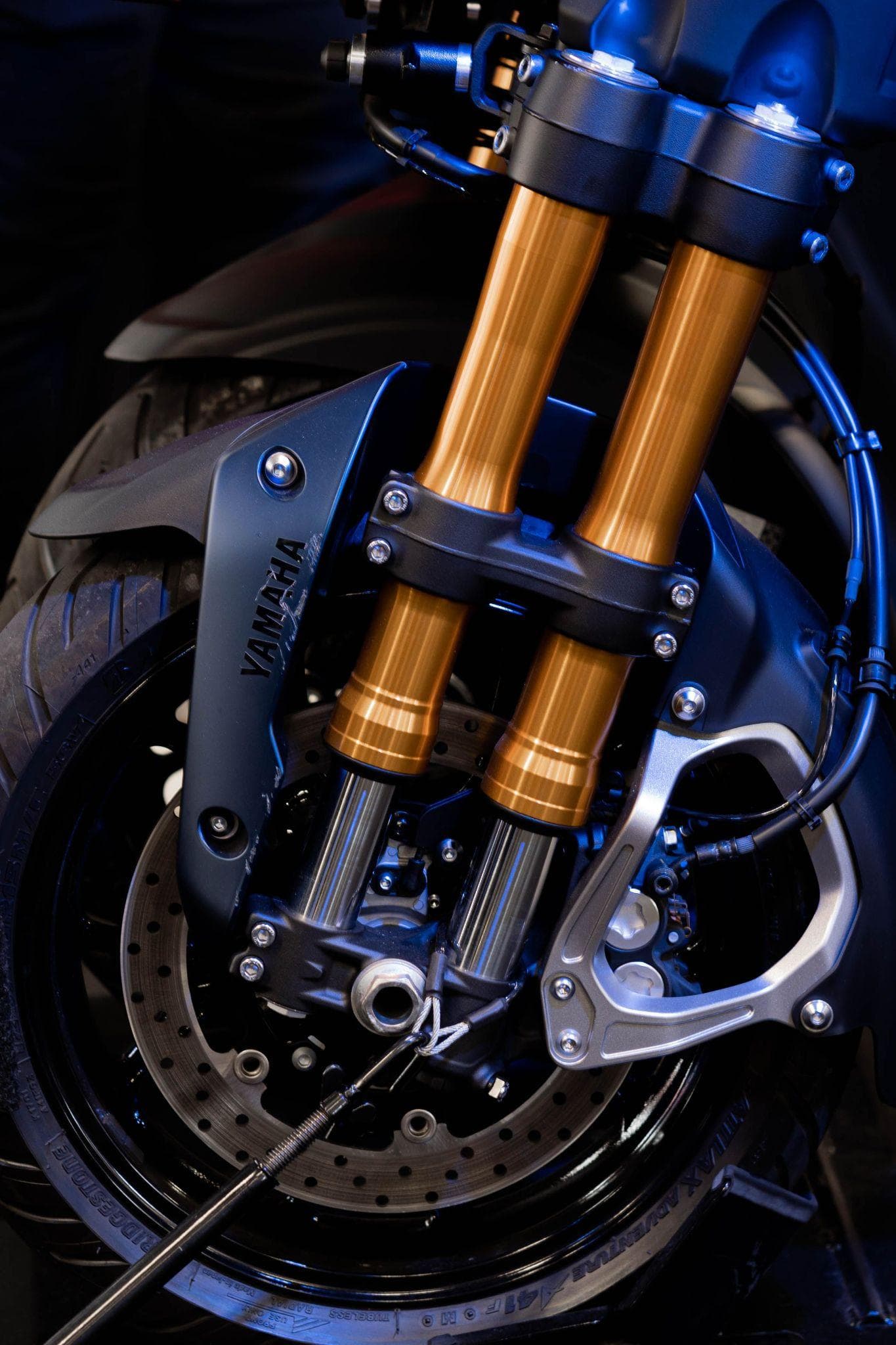 Gros plan sur la fourche inversée et le disque de frein avant d’une moto Yamaha