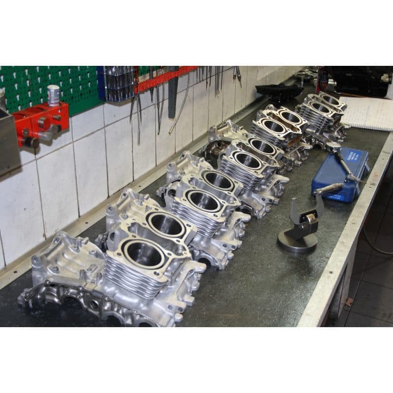 Carters moteur de motos alignés sur l’établi d’un atelier